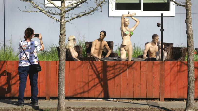 In this photo taken Monday, March 18, 2019, a woman stops to photograph a display of mannequins in Santa Rosa, Calif. Homeowner Jason Winduce set up the display, after a neighbor in the area complained to the city about his six-foot-tall fence. Winduce had to cut the fence to three feet. (Photo: Kent Porter/The Press Democrat via AP)