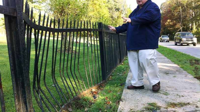 Stanley Spitler, superintendent of Ferncliff Cemetery, surveys the latest damage Friday to the cemetery’s wrought-iron fence after a driver along North Plum Street collided with it. The Ferncliff fence is a magnet for car crashes. Andrew McGinn/Staff
