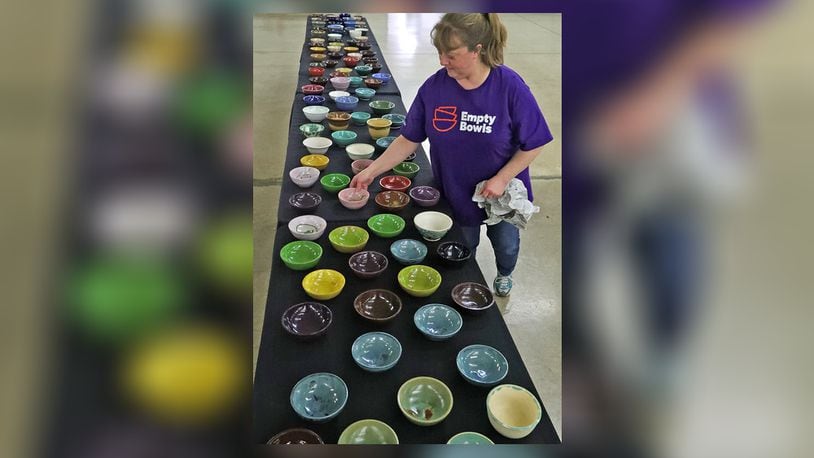 Wittenberg University will present its 28th annual Empty Bowls fundraiser in person for the first time since 2019 when it returns on March 23. Here, Melena Prasertsak, from Second Harvest Food Bank, set out bowls for last year's Annual Empty Bowls fundraiser in Champaign County. All proceeds from the event go to the Second Harvest Food Bank. FILE/BILL LACKEY/STAFF