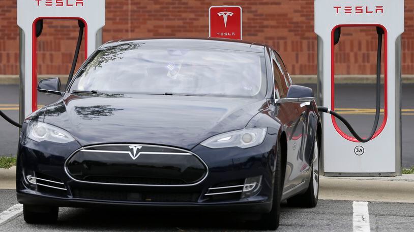 In this Saturday, June 24, 2017, photo, a Tesla car recharges at a charging station in Charlotte, N.C. AP Photo/Chuck Burton