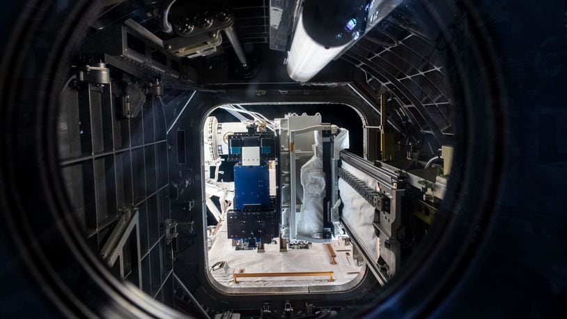 Materials International Space Station Experiment, or MISSE, shown in the blue panel on the airlock slide tray at the International Space Station as the Special Purpose Dexterous Manipulator grapples it. The MISSE spaceflight experiment is a collaboration among the Air Force Research Laboratory, NASA, Georgia Tech Research Institute and DuPont to study the effects of space weather on spacecraft materials. (Photo credit/NASA)