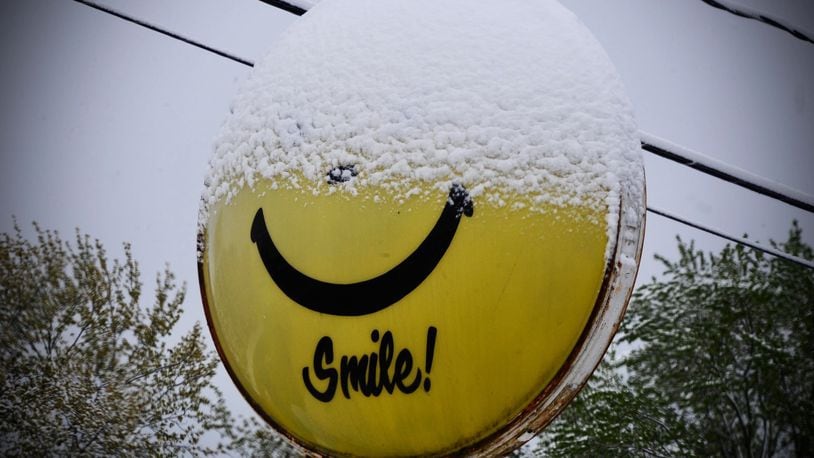 This sign near Fairborn says smile, even though half of it is covered with snow on Wednesday, April 21, 2021. MARSHALL GORBY\STAFF