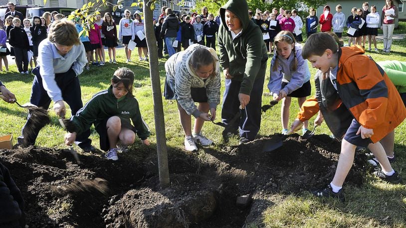 Students at St. Bernard Elementary plant a Chokecherry tree in a grassy lot behind the school Friday during an Arbor Day ceremony in 2020. Students from the school talked about the history of Arbor Day and read poetry about trees, and Springfield city officials read a proclamation during the ceremony. Staff photo by Bill Lackey