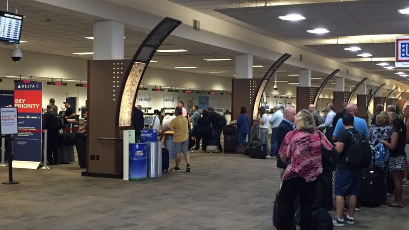 Travelers wait in long lines at Delta at Dayton International Airport Monday morning. JAROD THRUSH/STAFF