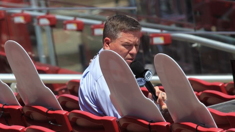 Jim Day, of Fox Sports Ohio, looks at four cardboard cutouts of fans in the stands during a game between the Reds and Tigers on Sunday, July 26, 2020, at Great American Ball Park in Cincinnati. David Jablonski/Staff