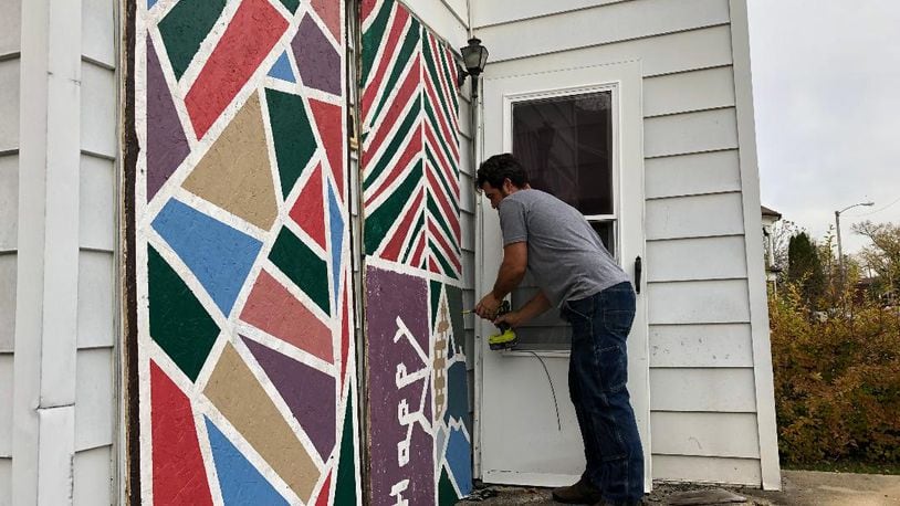 Velorossa Design owners Nate and Mandie Fleming saw an opportunity to improve abandoned Springfield properties by painting door and window panels to lessen the blight. Photo by Brett Turner