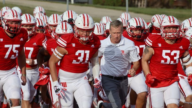 Wittenberg players and coach Jim Collins take the field before a game against Kenyon on Saturday, Sept. 16, 2023, at Edwards-Maurer Field in Springfield. David Jablonski/Staff