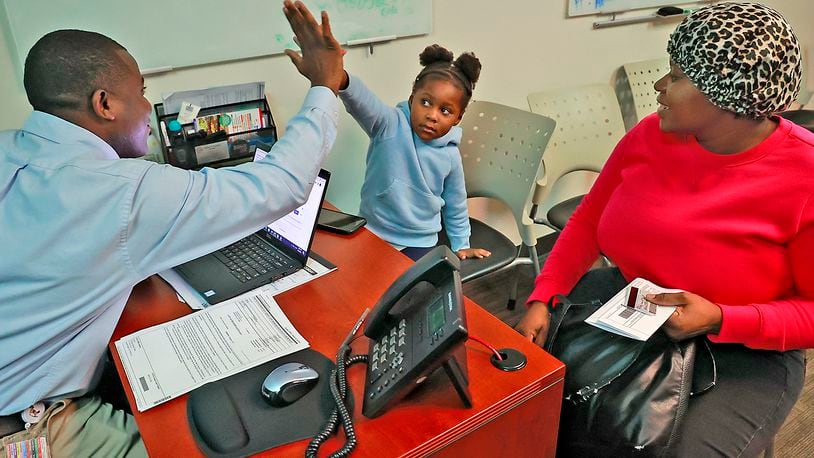 Johnson Salomon, a patient advocate and interpreter at the Rocking Horse Community Health Center in Springfield, gets a high five from Haitian immigrant Snica Leguerre after her mother Lormilia got clarification on some paperwork Wednesday, May 3, 2023 at Rocking Horse. BILL LACKEY/STAFF