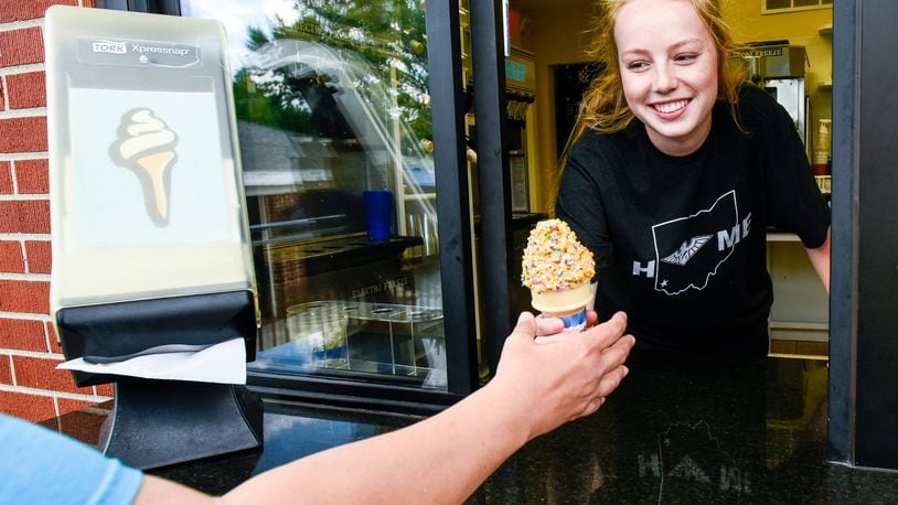 Kate Harvey, 16, serves an ice cream cone during her shift at Twist Ice Cream Company Wednesday, May 31 on Bethany Road in Liberty Twp. NICK GRAHAM/STAFF