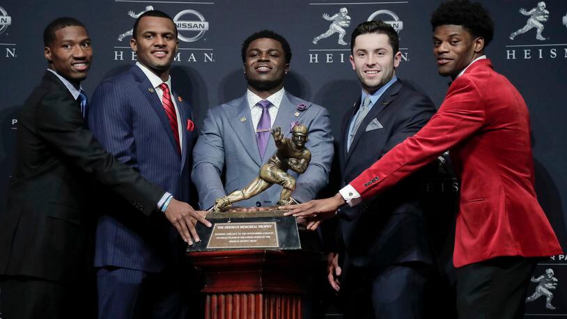Heisman Trophy finalists, from left, Oklahoma's Dede Westbrook, Clemson's Deshaun Watson, Michigan's Jabrill Peppers, Oklahoma's Baker Mayfield and Louisville's Lamar Jackson stand for a photo with the Heisman Trophy before attending the Heisman Trophy award ceremony, Saturday, Dec. 10, 2016, in New York. (AP Photo/Julie Jacobson)