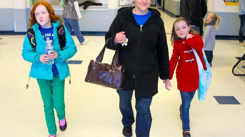 Charlotte Lovelace picks up her kids, Carrie, 10, and Molly, 8, at Middletown Christian School, Friday, March 8, 2013. Ohio governor John Kasich has proposed an expansion of Ohio's EdChoice school voucher program. The Lovelace's use publicly funded vouchers to send their girls to Middletown Christian School, which is a private school. GREG LYNCH / STAFF