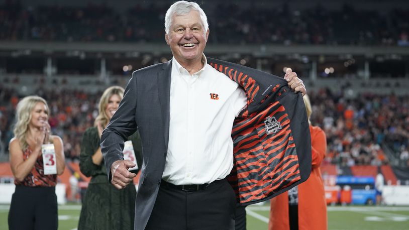 Former Cincinnati Bengals' Ken Anderson holds open his jacket during a "Ring of Honor" ceremony during an NFL football game between the Cincinnati Bengals and the Jacksonville Jaguars, Thursday, Sept. 30, 2021, in Cincinnati. (AP Photo/Michael Conroy)
