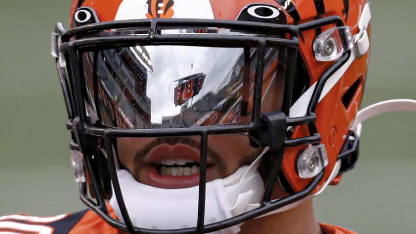 The scoreboard and seating area of Paul Brown Stadium are reflected in the visor of Cincinnati Bengals free safety Jessie Bates (30) as he warms up before an NFL football game against the Baltimore Ravens, Sunday, Jan. 3, 2021, in Cincinnati. (AP Photo/Aaron Doster)