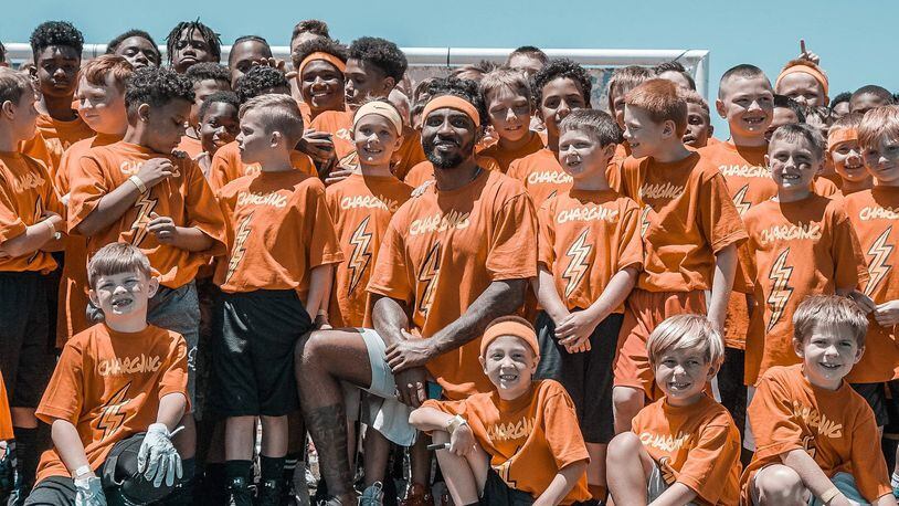 Wayne and Ohio State graduate Braxton Miller is shown with children from his CHARG1NG Camp. CONTRIBUTED