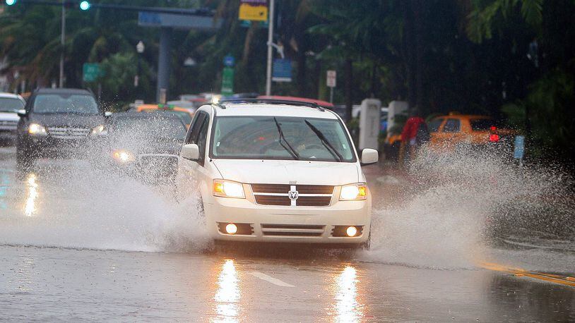 Cars move through the flooded roads caused by Tropical Storm Nicole in Miami Beach, Florida, Sept. 29, 2010. Hazard lights worsen the danger of driving in a downpour, safety experts say. (David Santiago/Miami Herald/TNS)