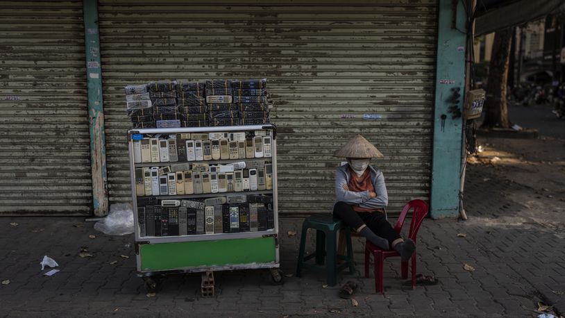 A vendor selling used remote controls for various home appliances takes a nap in Nhat Tao market, the largest informal recycling market in Ho Chi Minh City, Vietnam, Sunday, Jan. 28, 2024. (AP Photo/Jae C. Hong)