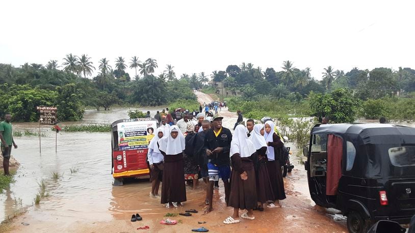 Schoolchildren stranded on a damaged River Zingiziwa bridge in Dar Esalaam, Tanzania Thursday, April 25, 2024. Flooding in Tanzania caused by weeks of heavy rain has killed 155 people and affected more than 200,000 others, the prime minister said Thursday. (AP Photo)