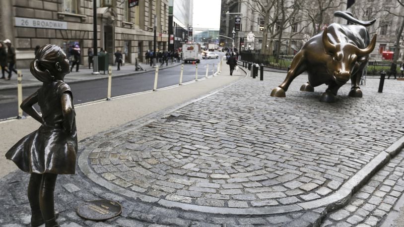 A bronze statue of a defiant girl faces “Charging Bull” in the Financial District of New York on International Womens Day, March 8, 2017. State Street Global Advisors, a unit of State Street Corp., installed the Kristen Visbal statue in front of Arturo Di Modica’s iconic charging bull by as part of its new campaign to pressure companies to add more women to their boards. (MUST CREDIT: Jeenah Moon/Bloomberg)