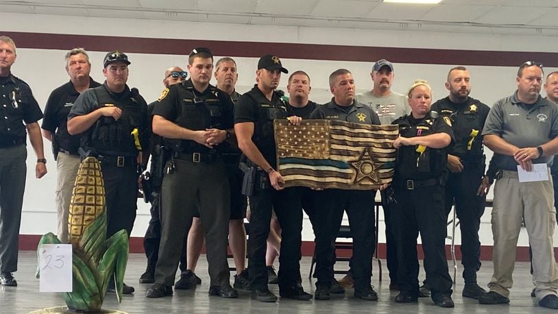 Clark County Sheriff's Office employees stand with a wood carving created to honor Deputy Matt Yates Thursday evening. Photo provided by Dean Blair.