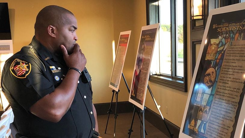 Deputy Matthew Yates checks out one of the posters explaining Islamic values and culture during Springfield's Islamic Day of Ohio event in October 2019. Yates was a recipient of the community heroes awards given that evening. Photo by Brett Turner
