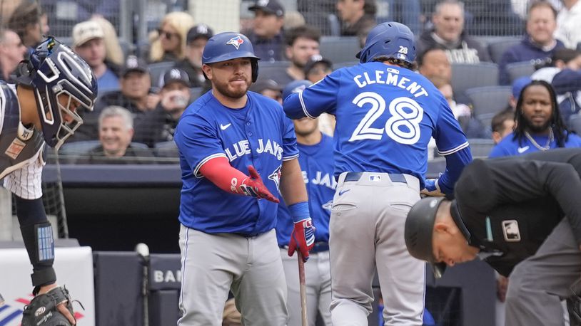 Toronto Blue Jays' Alejandro Kirk, left, greets Ernie Clement (28) after Clement hit a home run during the seventh inning of the baseball game against the New York Yankees at Yankee Stadium in New York, Friday, April 5, 2024.(AP Photo/Seth Wenig)