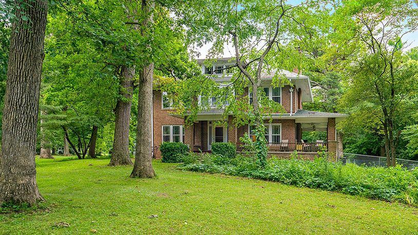 Originally built in 1918, the brick 2-story sits among mature trees on a 2.6-acre lot. The home offers about 2,660 sq. ft. of living space with 4 bedrooms and a second-floor sunroom. A covered porch wraps around the front and side of the home. CONTRIBUTED PHOTO