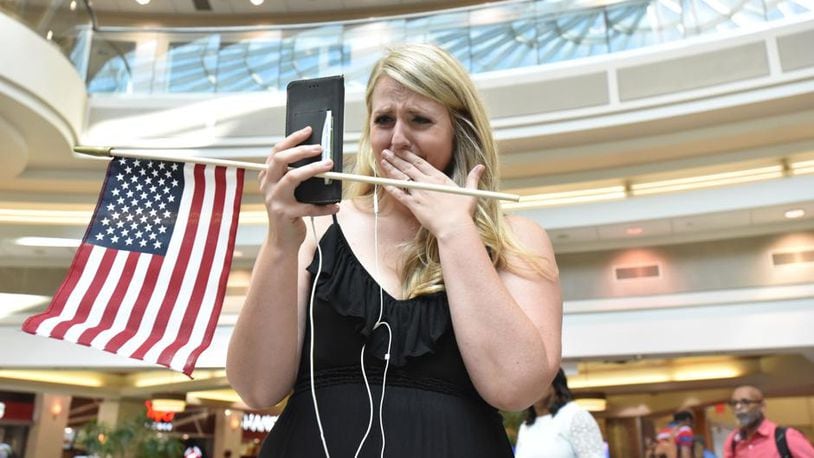 Lindsey Eastwood can’t hide her emotion as she broadcasts livestream video of the flash mob to welcome her husband, Jon Eastwood, at Hartsfield-Jackson International Airport’s domestic terminal atrium on Friday, Aug. 3, 2018. Weather forced a cancellation for Jon’s flight, but he made it in a day later for their in-person reunion. (Photo: Hyosub Shin/The Atlanta Journal-Constitution)