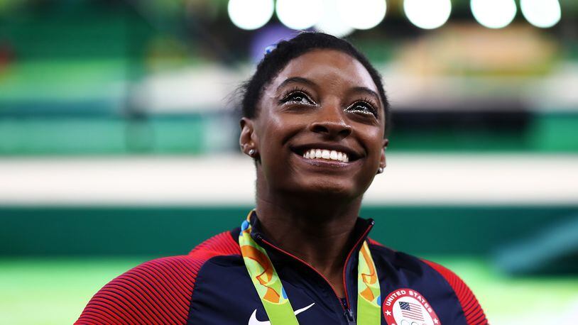 RIO DE JANEIRO, BRAZIL - AUGUST 11: Gold medalist Simone Biles of the United States poses for photographs after the medal ceremony for the Women's Individual All Around on Day 6 of the 2016 Rio Olympics at Rio Olympic Arena on August 11, 2016 in Rio de Janeiro, Brazil. (Photo by Elsa/Getty Images)