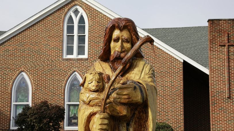 A tree, which once stood in front of the Grace United Methodist Church was carved into a shephard by a local artist. Bill Lackey/Staff