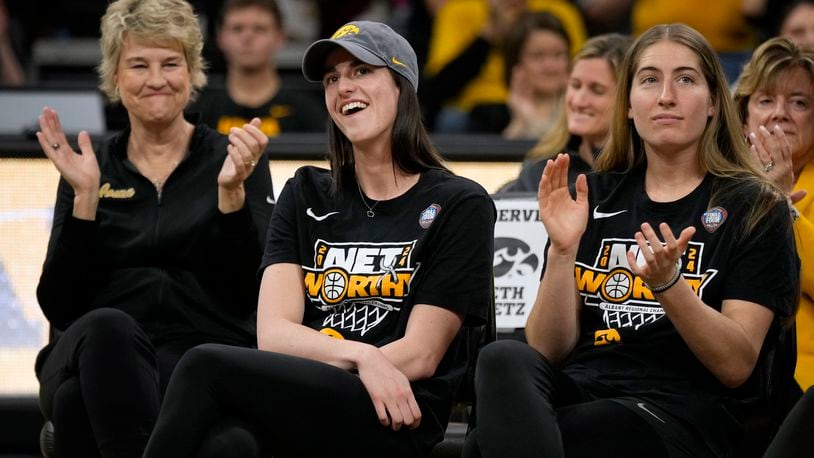 Iowa guard Caitlin Clark, center, sits with coach Lisa Bluder, left, and guard Kate Martin, right, as she finds out her number will be retired, during an Iowa women's basketball team celebration Wednesday, April 10, 2024, in Iowa City, Iowa. Iowa lost to South Carolina in the college basketball championship game of the women's NCAA Tournament on Sunday. (AP Photo/Charlie Neibergall)
