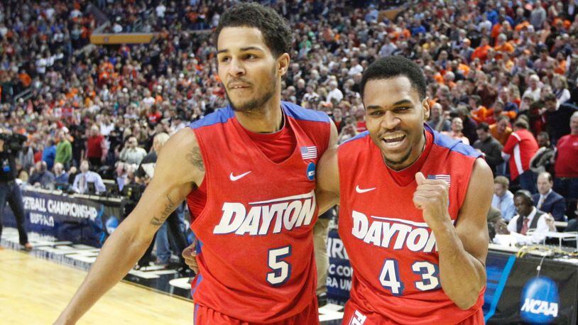 Dayton's Vee Sanford, right, pumps his fist and leaves the court with Devin Oliver after hitting the game-winning shot against Ohio State in the second round of the NCAA tournament on Thursday, March 20, 2014, at the First Niagara Center in Buffalo, N.Y. David Jablonski/Staff