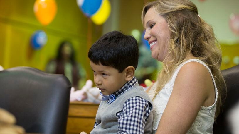 Kristin Finan looks on at her son, Joaquin Badgley-Finan, 4 during the adoption ceremony in Austin, Texas, on Thursday. At the event, 44 children celebrated Austin Adoption day with 30 new families and kicked off the National adoption awareness Month. The number of overseas adoptions in the U.S. and Ohio are down. (RICARDO B. BRAZZIELL / AMERICAN-STATESMAN)