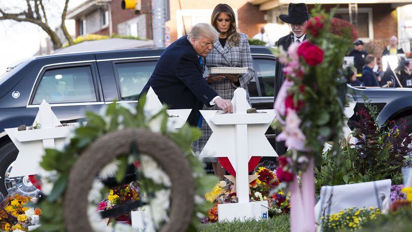President Donald Trump, accompanied by first lady Melania Trump and Rabbi Jeffery Myers, lays a stone at the makeshift memorial outside the synagogue named Tree of Life in Pittsburgh on Tuesday, Oct. 30, 2018. The president, accompanied by his wife, daughter and son-in-law, arrived in Pittsburgh as the city began to bury the victims of Saturday’s synagogue attack. (Doug Mills/The New York Times)