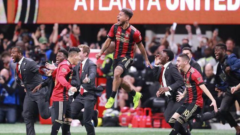Atlanta United's Josef Martinez leaps in the air and Miguel Almiron charges the field celebrating winning the MLS CUP 2-0 over the Portland Timbers on Saturday, Dec 8, 2018, in Atlanta.