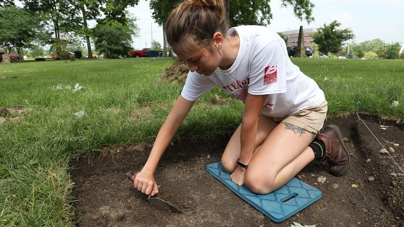 Wittenberg student Casey Juday, from New Carlisle, scrapes the ground in her archeological dig site Thursday, May 31, 2018 at the Columbia Street Cemetery. Bill Lackey/Staff