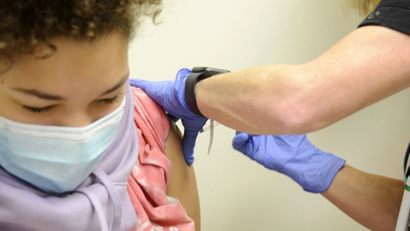 Brooklyn Brundidge, 12, a seventh-grader at Garfield Middle School in Hamilton, receives a vaccine shot on Wednesday, Sept. 14, 2022, from Public Health Nurse Betsy Waldeck at the Butler County General Health District clinic in downtown Hamilton. MICHAEL D. PITMAN/STAFF