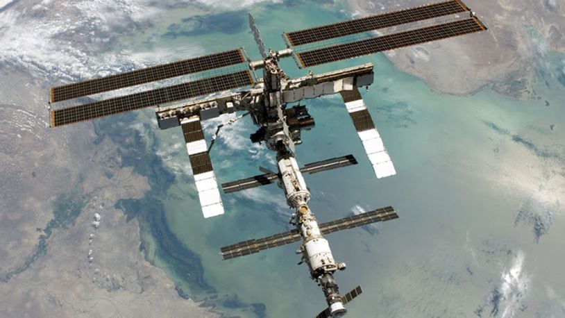 The International Space Station seem from above with Earth in the background.