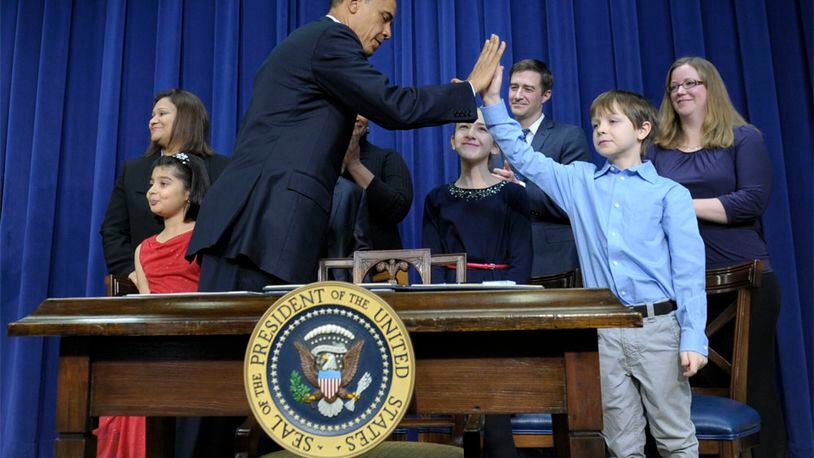 President Barack Obama gets a high-five from 8-year-old letter writer Grant Fritz during a news conference on proposals to reduce gun violence, Wednesday, Jan. 16, 2013, in the South Court Auditorium at the White House in Washington. Obama and Biden were joined by law enforcement officials, lawmakers and children who wrote the president about gun violence following the shooting at an elementary school in Newtown, Conn., last month.