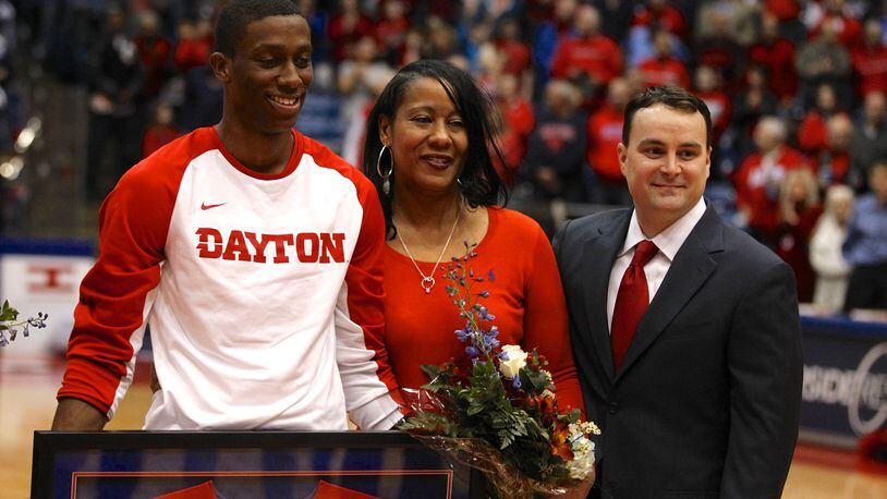 Jordan Sibert, left, and his mom Sheila stand with Dayton coach Archie Miller on Senior Night on Tuesday, March 3, 2015, at UD Arena. David Jablonski/Staff