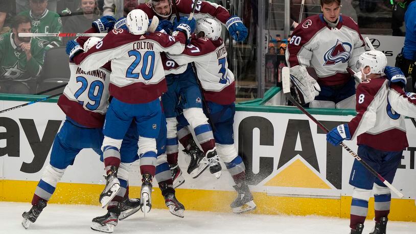 Colorado Avalanche left wing Miles Wood (28) is lifted off the ice by Nathan MacKinnon (29), Ross Colton (20) and Casey Mittelstadt (37) after Wood scored in overtime of Game 2 of an NHL hockey Stanley Cup second-round playoff series against the Dallas Stars in Dallas, Tuesday, May 7, 2024. Cale Makar (8) and Justus Annunen (60) look on at the celebration. (AP Photo/LM Otero)