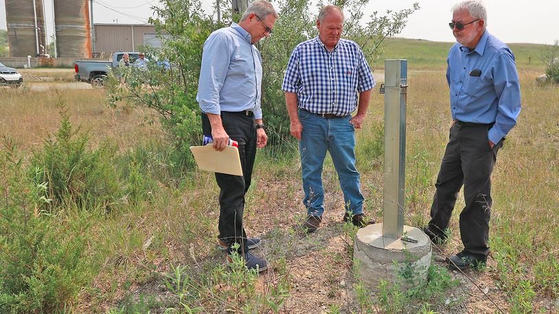 Bob Rule (left), from the potentially responsible party group, German Twp. trustee Rodney Kaffenbarger (center), and Larry Ricketts, from the People for Safe Water group, look over a testing well for the Tremont City Barrel Fill on Wednesday, June 7, 2023. BILL LACKEY/STAFF