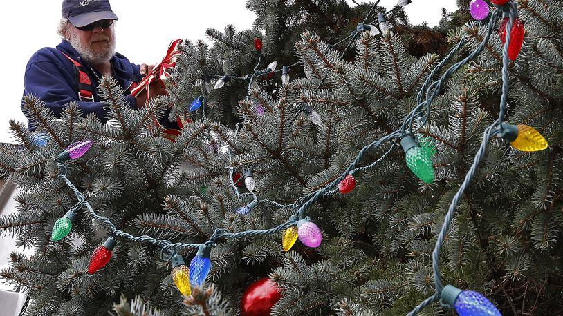 Ron Wright, an employee of the New Carlisle, decorated the city’s Christmas tree at the intersection of North Main Street and Washington Street last year. BILL LACKEY/STAFF