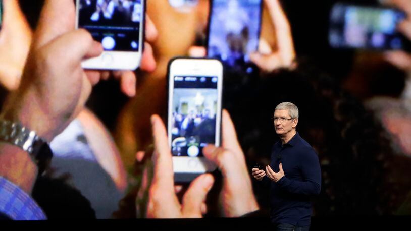 FILE - In this Wednesday, Sept. 7, 2016, file photo, Apple CEO Tim Cook announces the new iPhone 7 during an event to announce new products, in San Francisco. Apple reported Tuesday, Oct. 25, 2016, that it sold 45.5 million iPhones in the previous quarter, 5 percent fewer than it sold a year earlier. But the giant tech company's rosy forecast for the holidays was better than what Wall Street had been expecting. (AP Photo/Marcio Jose Sanchez, File)