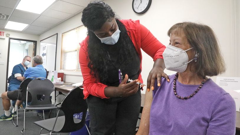 Claudia Fett gets her COVID booster shot Thursday, Sept. 8, 2022 from Ocie Orr, a nurse in the Vaccine Clinic at the Clark County Combined Health District. BILL LACKEY/STAFF