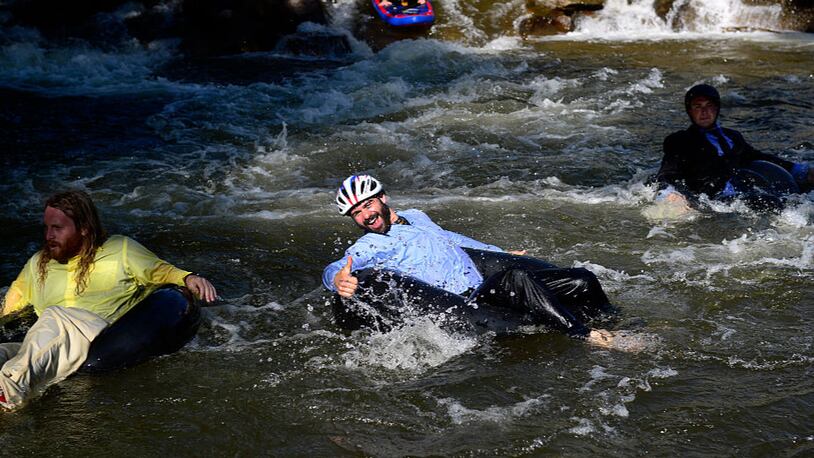 Employees from Boulder's LogRhythm Inc. and others, don their professional attire and jump into Boulder Creek on inner tubes and float to work during "Tube to Work Day."