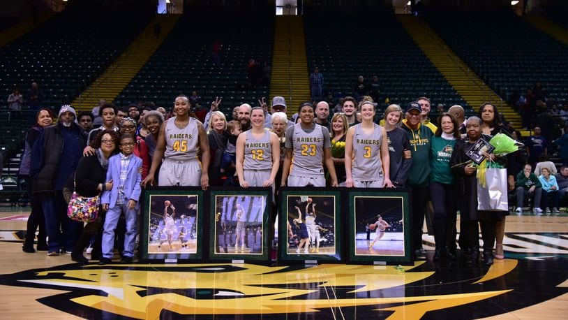 Wright State’s four seniors (from left) Imani Partlow, Mackenzie Taylor, Emily Vogelphol and Symone Simmons are joined by friends and family after Sunday’s Senior Day win over Youngstown State at the Nutter Center. Joseph Craven/CONTRIBUTED