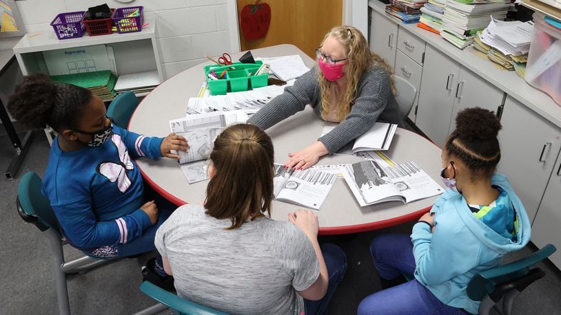 Beckitt Bostick, a second grade teacher at Perrin Woods Elementary, works with a small group of students Wednesday. BILL LACKEY/STAFF