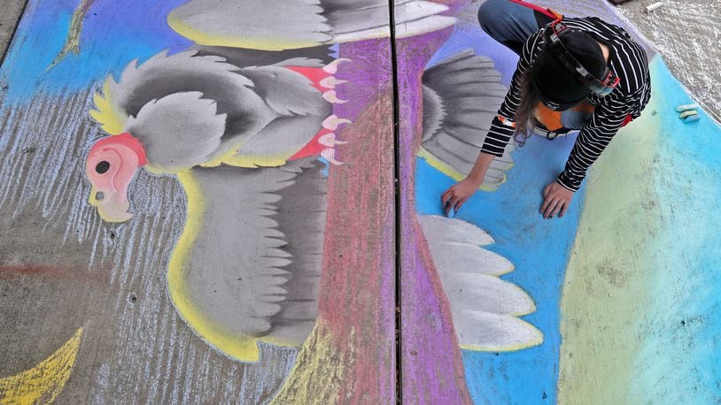 Jennah Kuhn works on her chalk artwork during the National Trail Parks and Recreation District's annual ChalkFest Saturday, Oct. 1, 2022 at National Road Commons Park. BILL LACKEY/STAFF