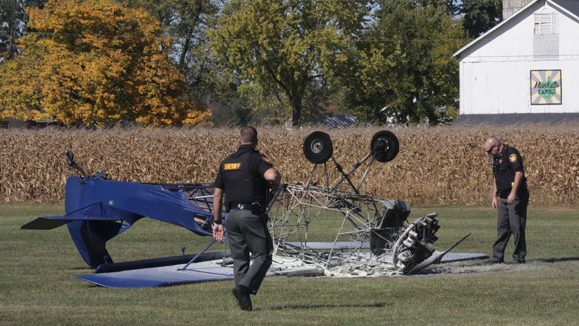 Clark County Sheriff’s deputies look over the remains of an airplane that crashed and burst into flames on the runway Tuesday, Oct. 13, 2020, at the Andy Barnhart Memorial Airport in New Carlisle. BILL LACKEY/STAFF