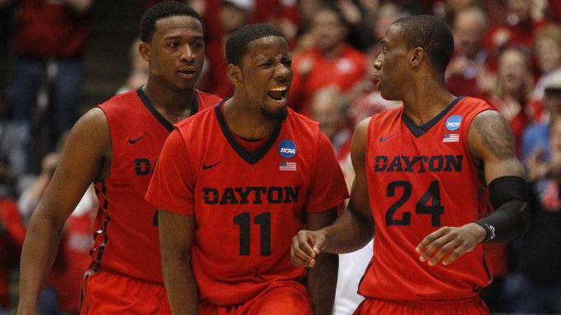 Dayton’s Scoochie Smith, center, celebrates after a play with Kendall Pollard, left, and Jordan Sibert in the second half against Boise State in the First Four on Wednesday, March 17, 2015, at UD Arena. David Jablonski/Staff